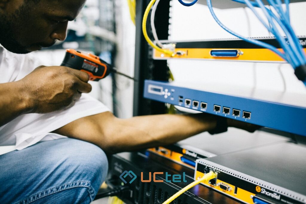 Technician inspecting mobile signal booster equipment in a telecom cabinet