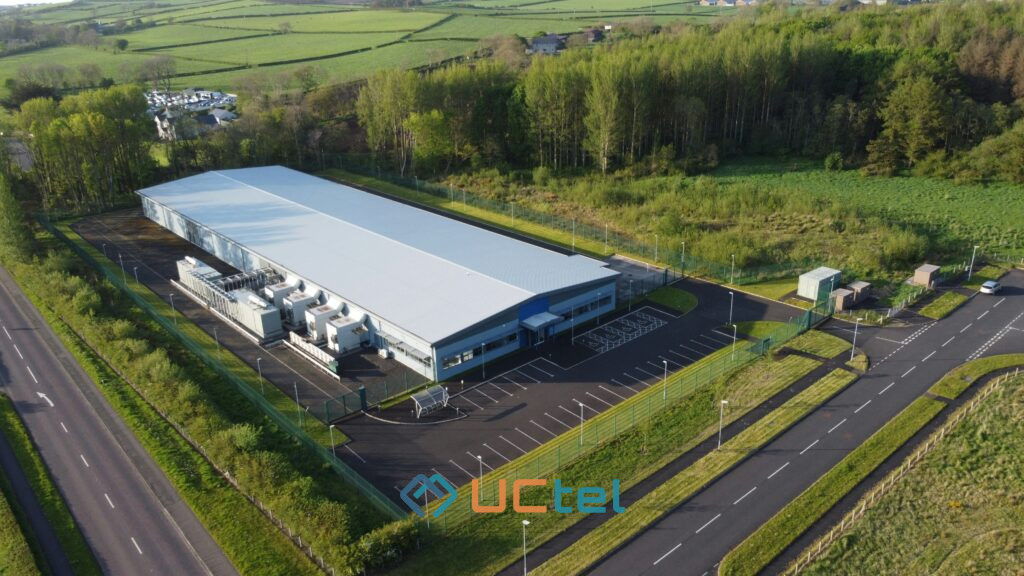 Aerial view of a data centre facility surrounded by greenery, illustrating mobile signal improvement strategies for critical infrastructure