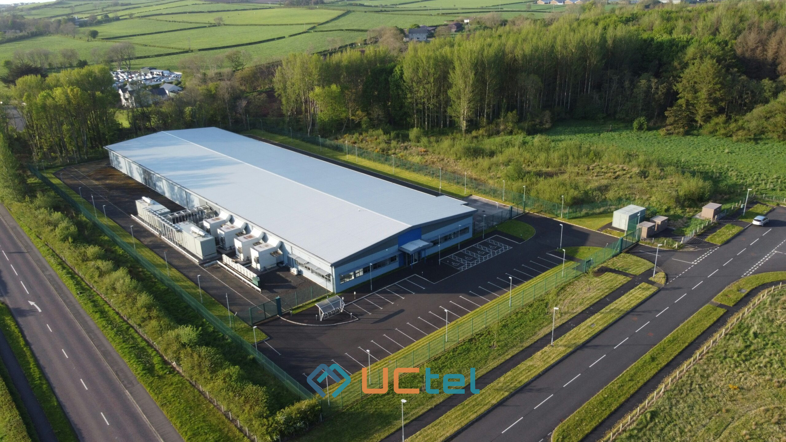 Aerial view of a data centre facility surrounded by greenery, illustrating mobile signal improvement strategies for critical infrastructure